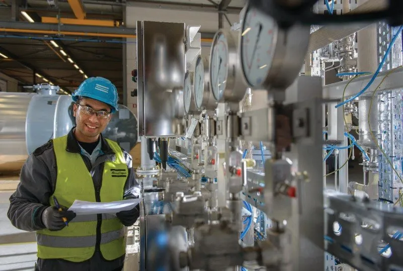En ingeniør med et skriveunderlag på et industrianlæg (foto: Atlas Copco)