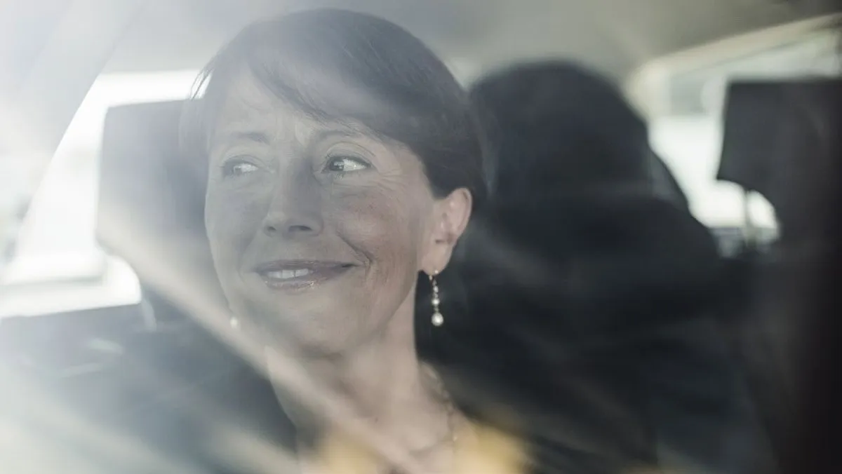 En smilende passager på bagsædet af en taxa (foto: Cabonline)